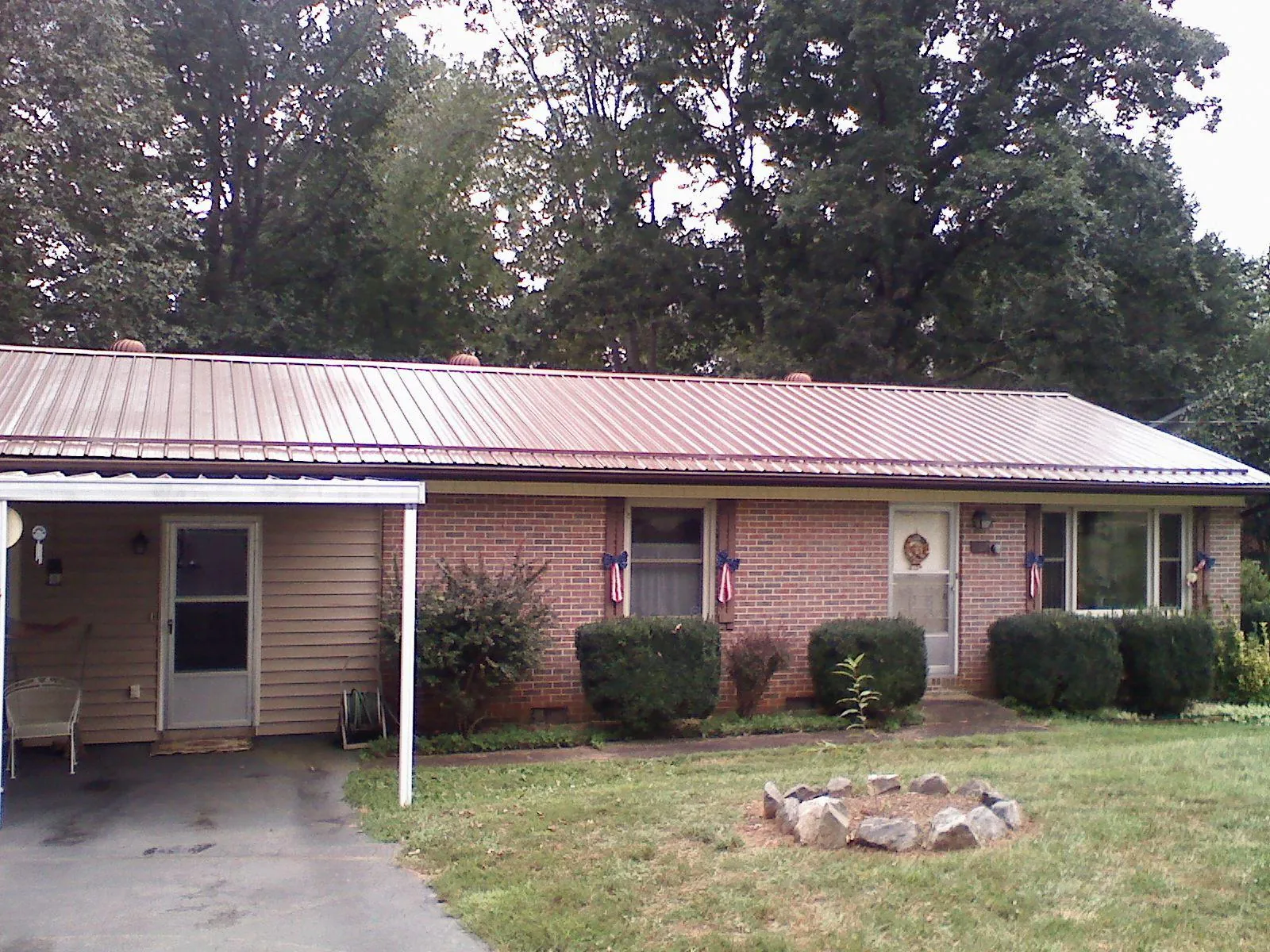Bronze metal roof and carport on a brick ranch home — Roof Repair work by our crew in Waltham